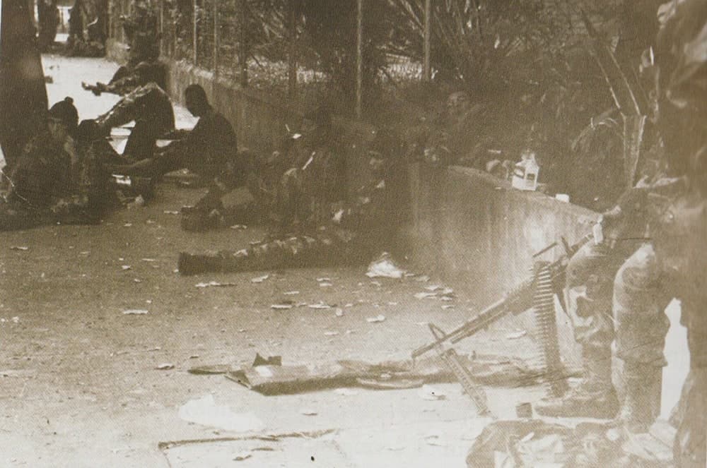 Marines sitting outside the perimeter of Camp Aguinaldo