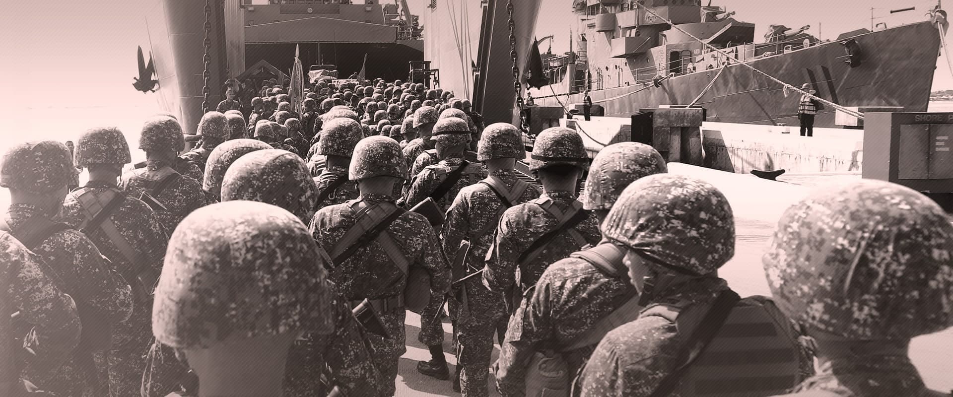 A group of soldiers in uniform and helmets, seen from behind, boarding or standing near a large ship. The uniforms have a distinct camouflaged pattern. 